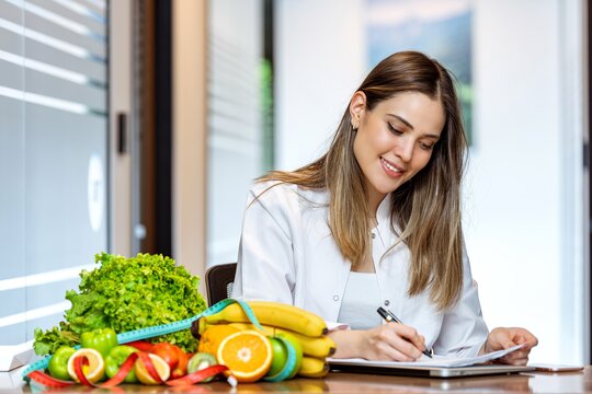 240410_artikelbild_frau-gemuese-massband-notizen-laptop_gettyimages-1258586742.jpg Eine Frau sitzt am Tisch und macht sich Notizen. Daneben liegt ein Haufen Gemüse und ein Maßband.