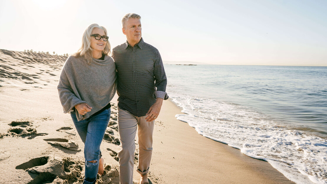Ein älteres Paar bei einem Spaziergang am Strand.