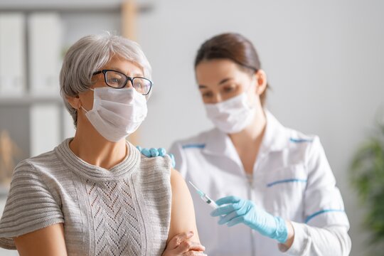 211118_frau_aerztin_impfung_corona_shutterstock_1868898253.jpg Ältere Damen mit Mundschutz bekommt von einer Ärztin mit Mundschutz eine Spritze in den Oberarm.