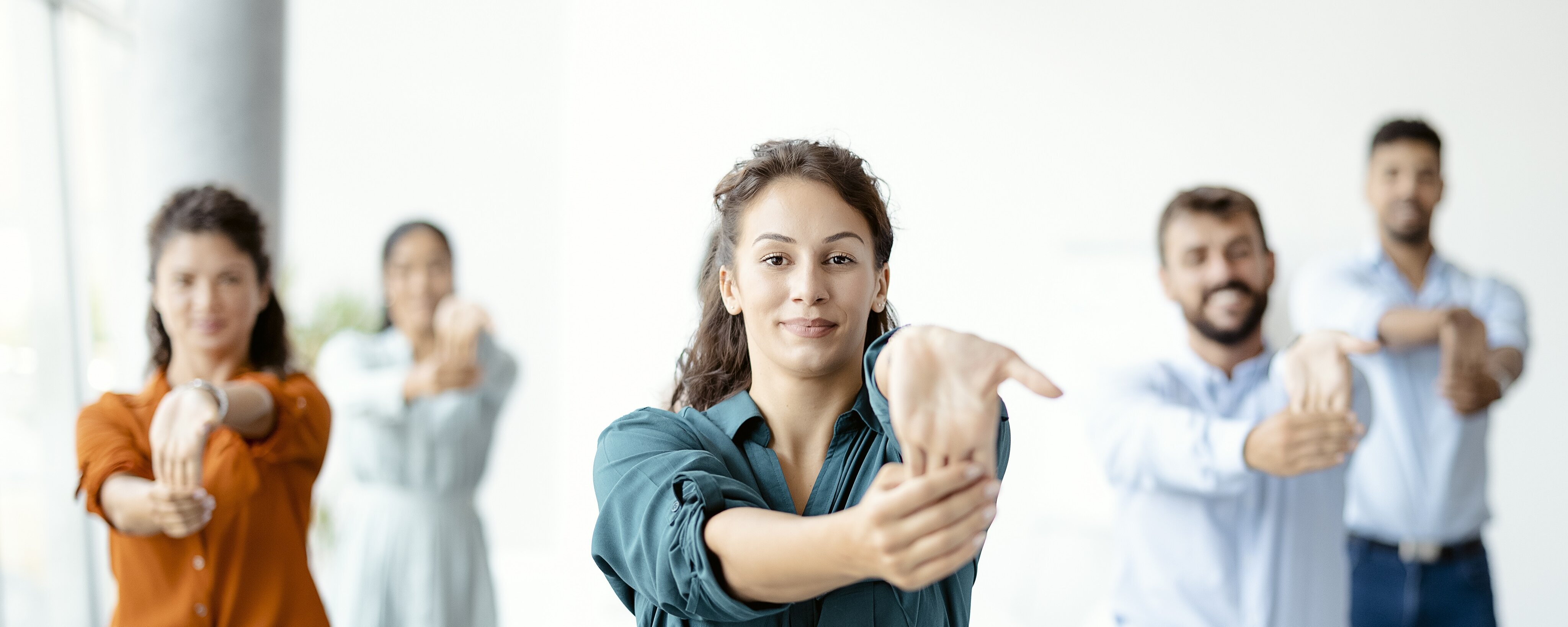 Mehrere Personen in Businesskleidung, die ihre Hände dehnen