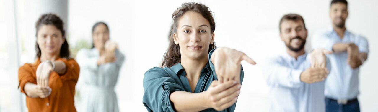 Mehrere Personen in Businesskleidung, die ihre Hände dehnen