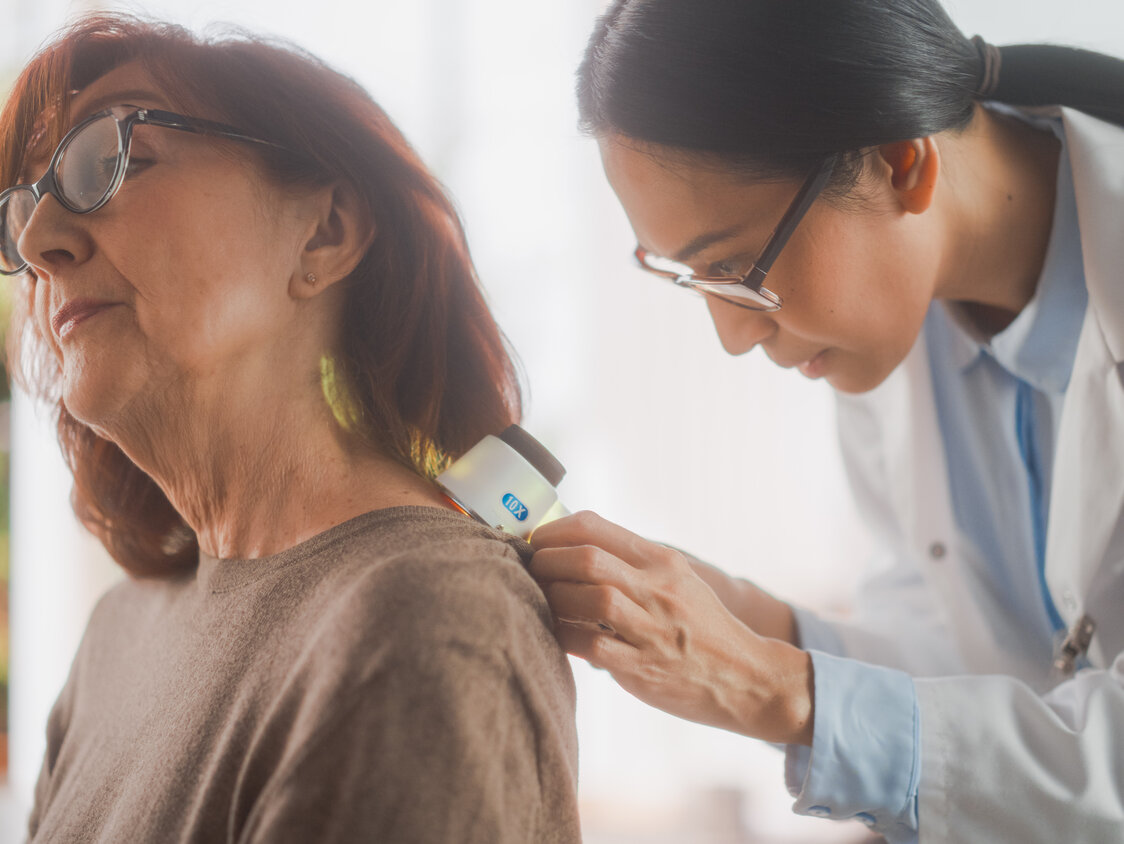 Eine Ärztin untersuch die Haut einer Patientin.