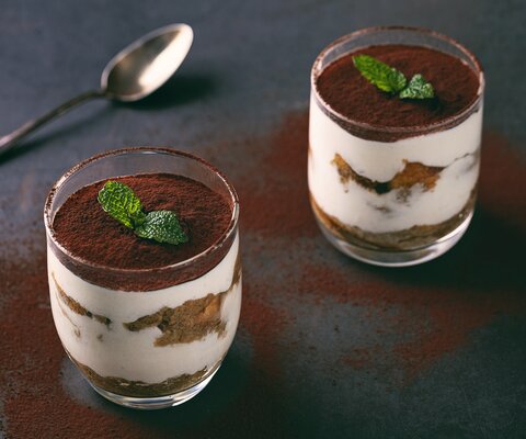 Tiramisu im Glas auf dem Tisch mit Löffel