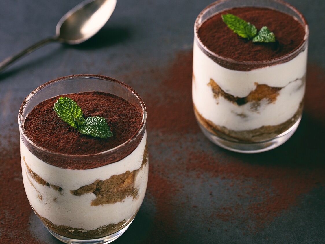 Tiramisu im Glas auf dem Tisch mit Löffel