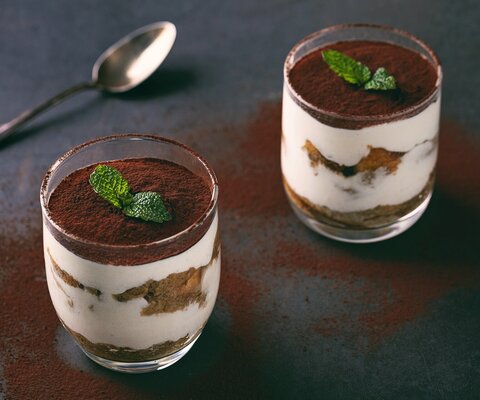 Tiramisu im Glas auf dem Tisch mit Löffel