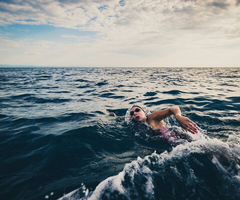 Eine Frau schwimmt im Meer.