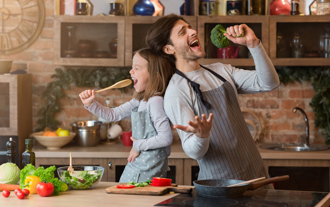 Ein Mann und eine Frau stehen in der Küche und singen und tanzen.