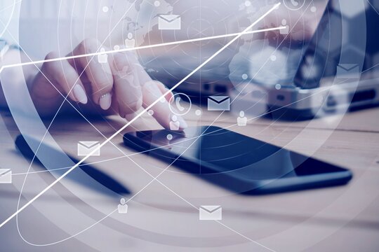 Eine Frau tippt auf ein Handy. Im Vordergrund werden virtuelle Symbole angezeigt.