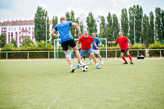 Senioren-Fußballspieler in Aktion auf grünem Rasen.