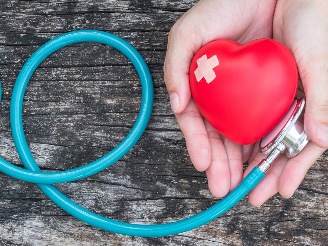 Hände mit Plastikherz und Stethoskop