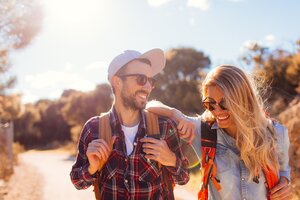 Junges Paar mit Sonnenbrillen und Rucksäcken im Urlaub.