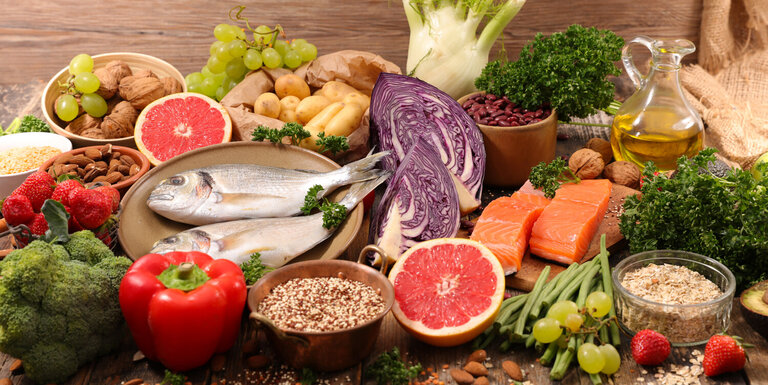 Ein Tisch voller Obst, Gemüse und Fisch.