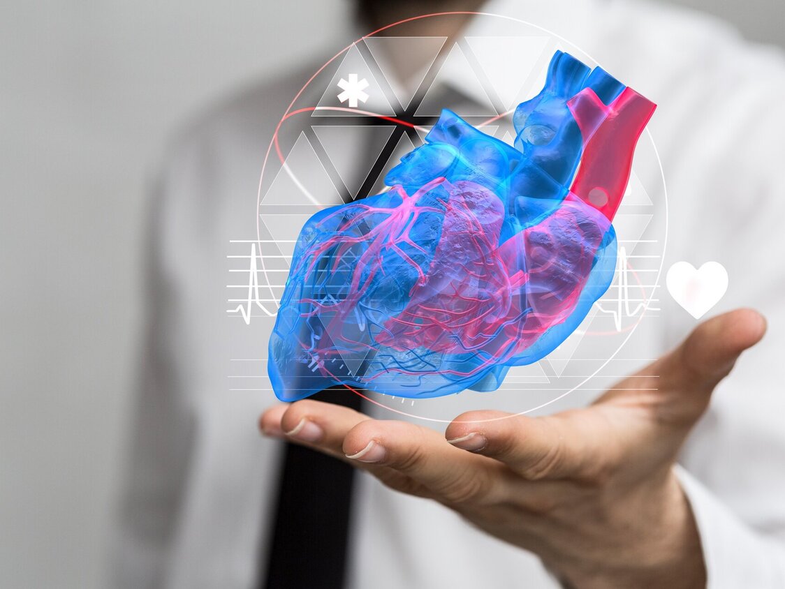 Ein Arzt hält seine offene Hand hoch und darüber schwebt ein virtuelles Herz.