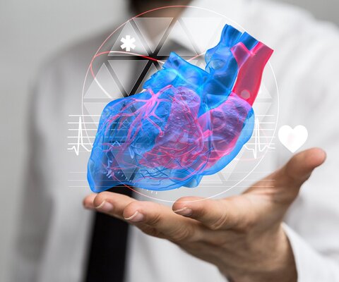 Ein Arzt hält seine offene Hand hoch und darüber schwebt ein virtuelles Herz.