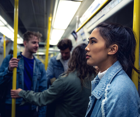 Frau steht in der U-Bahn