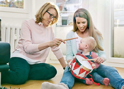 Oma, Mutter und Tochter sitzen auf dem Boden und trommeln.