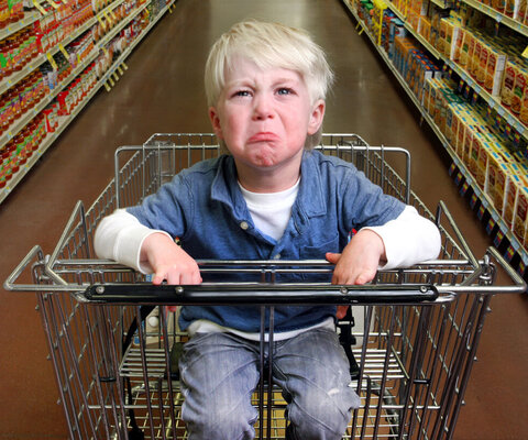 Boy crying in grocery cart.