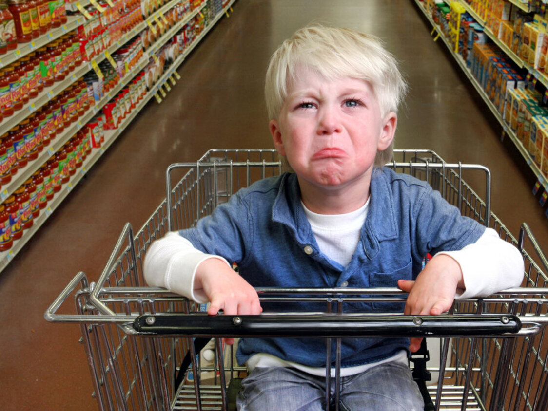 Boy crying in grocery cart.