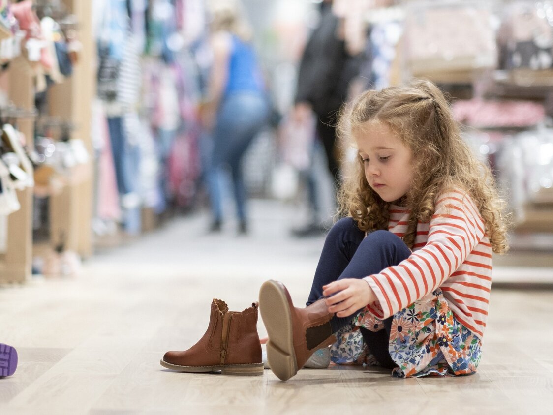 Ein Mädchen probiert Schuhe an.