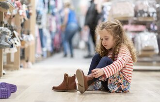 Ein Mädchen probiert Schuhe an.