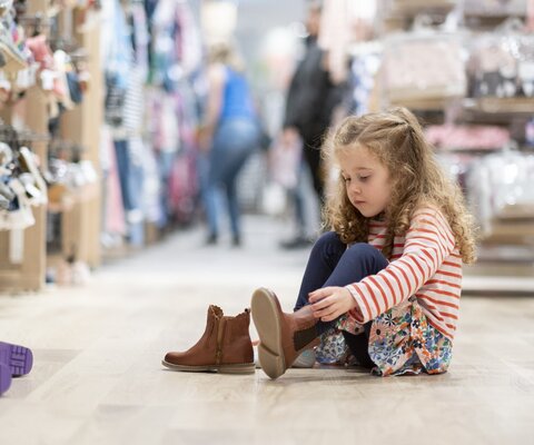 Ein Mädchen probiert Schuhe an.
