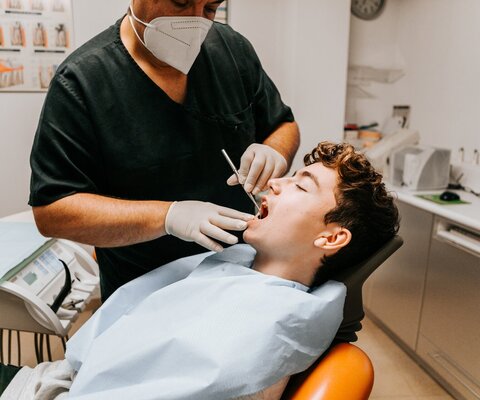Ein Zahnarzt überprüft die Zähne eines Jungen