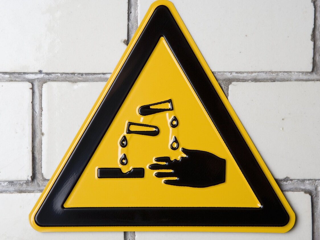 Gelbes Warnschild für Verätzungs- und Säuregefahr.