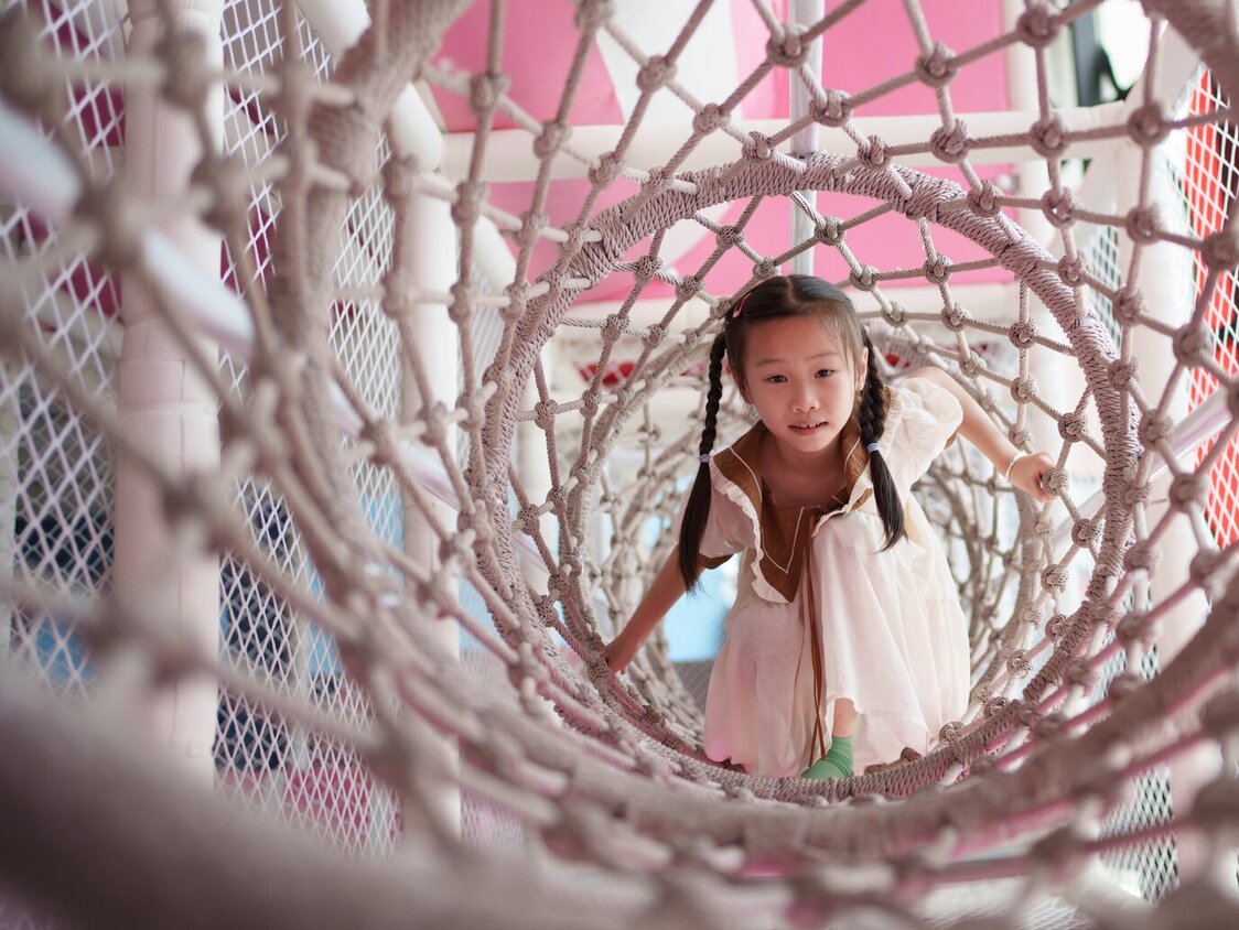 Kleines Mädchen spielt in einem Indoorspielplatz.