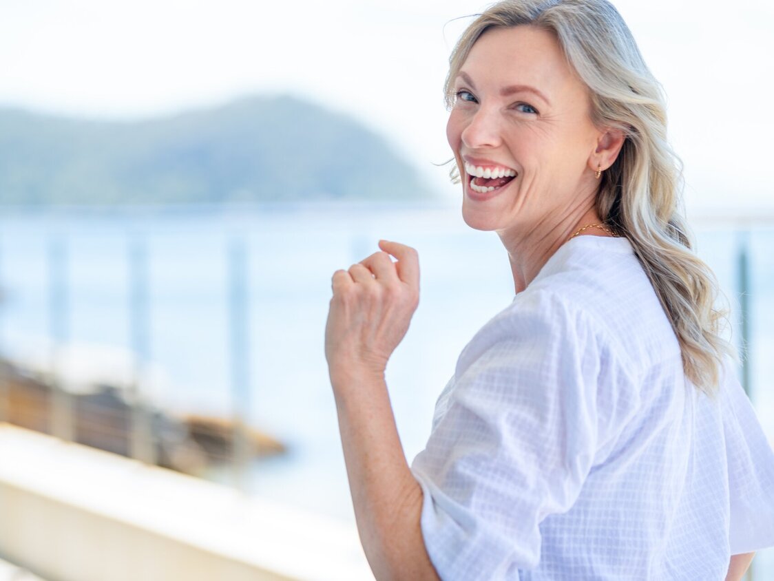 Eine Frau dreht sich im Laufen um und lacht.