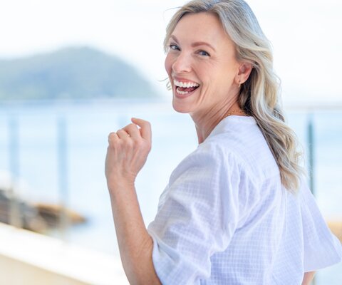 Eine Frau dreht sich im Laufen um und lacht.