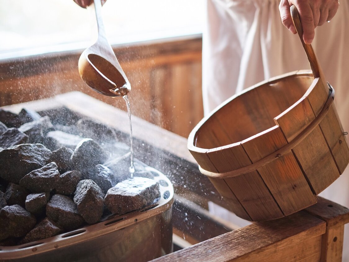 Ein Mann macht einen Aufguss in der Sauna.