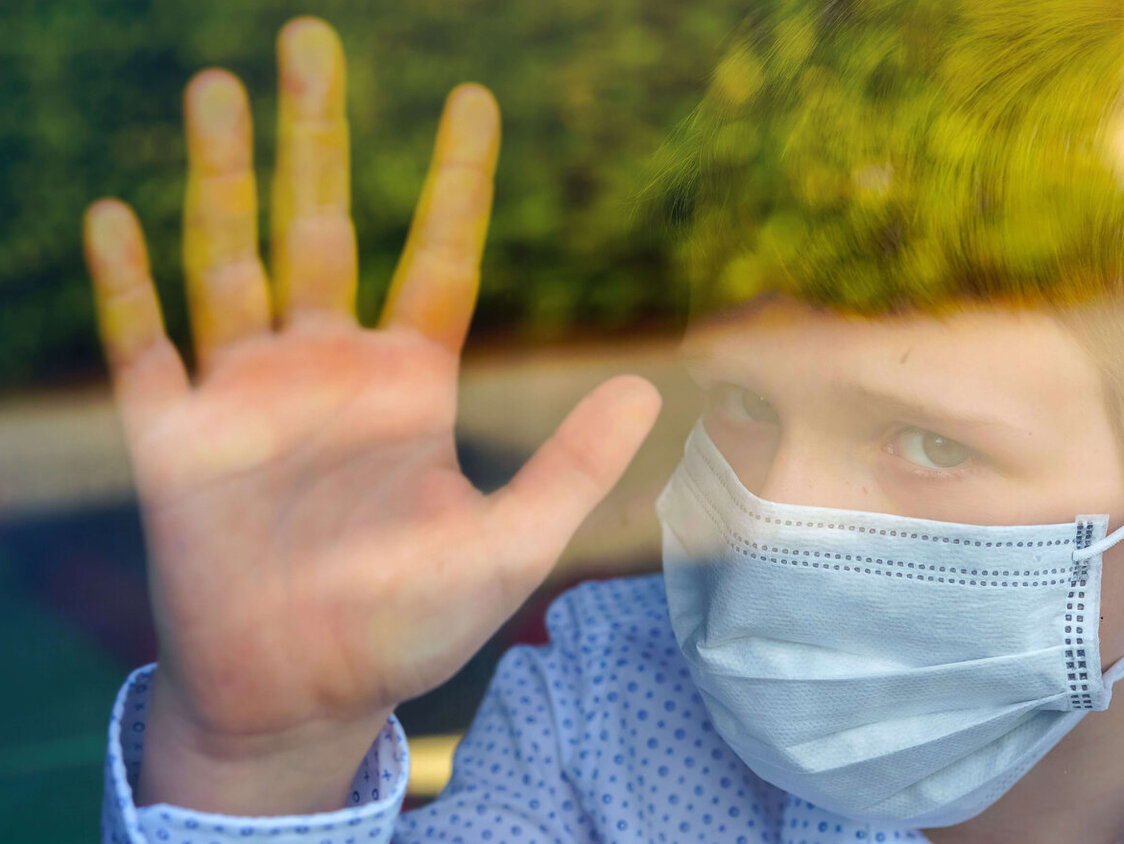 trauriges Kind mit Atemschutzmaske