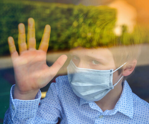 trauriges Kind mit Atemschutzmaske