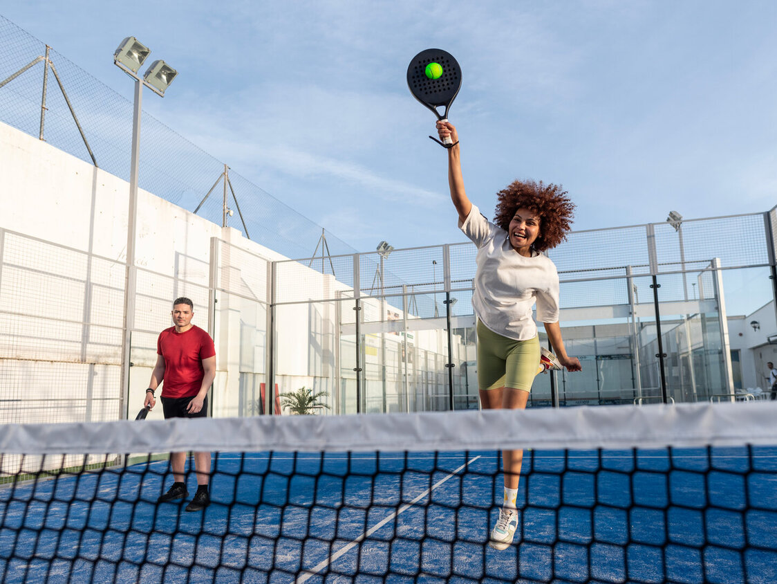 Zwei Personen sind auf einem Padelcourt und spielen Padel
