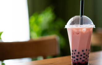 Bubble-Tea in einem Plastikbecher auf einem Tisch.