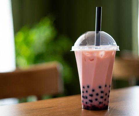 Bubble-Tea in einem Plastikbecher auf einem Tisch.