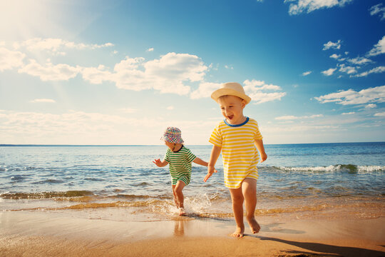 1010324137 Boy,And,Girl,Playing,On,The,Beach,On,Summer,Holidays.