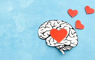 Ein Gehirn, gezeichnet, auf einem blauen Untergrund mit roten Herzen.