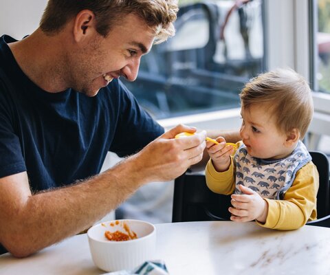 Mann füttert Kleinkind