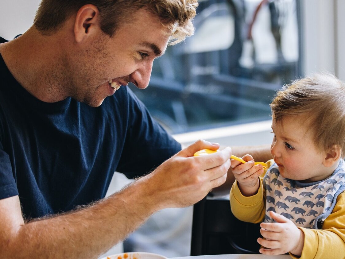 Mann füttert Kleinkind