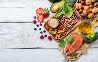 Eine Platte mit rohem Fisch, Nüsse, Obst und Gemüse.