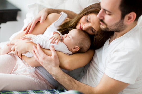 220426_artikelbild_familie-kuschelt-baby_gettyimages-513753066.jpg  Ein Mann hält seine Frau und ein Baby im Arm.