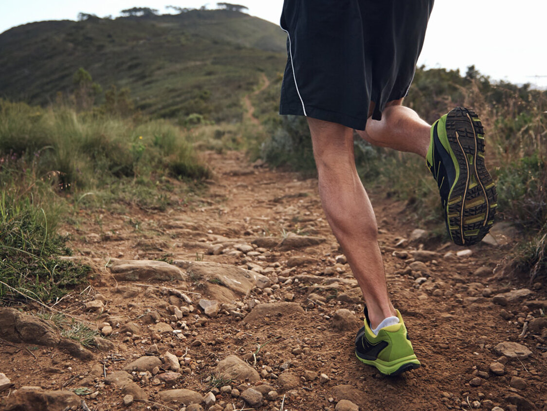  Ein Jogger, der sich in Richtung eines Berges bewegt.