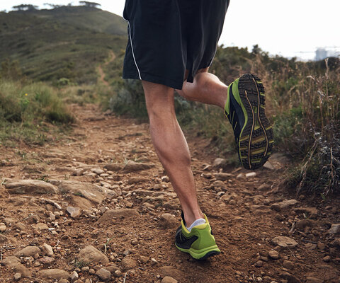  Ein Jogger, der sich in Richtung eines Berges bewegt.