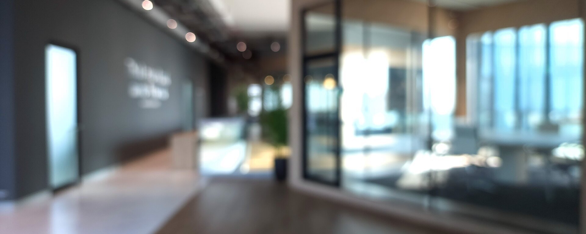 Man sieht verschwommen einen Büroflur und einen Konferenzraum.