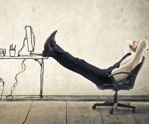 Mann zurückgelehnt auf dem Bürostuhl