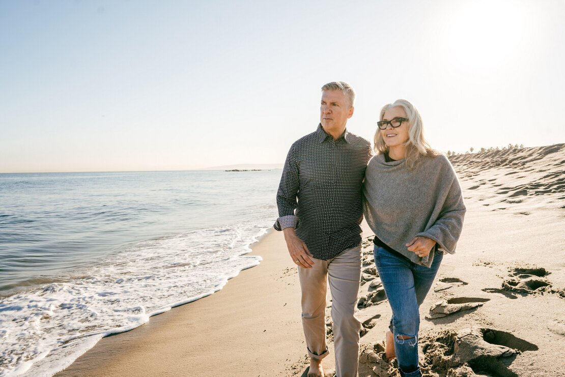 Ein älteres Paar bei einem Spaziergang am Strand.