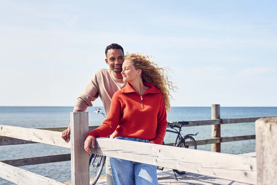 Ein Mann und eine Frau stehen auf einem Steg und gucken in die Ferne.