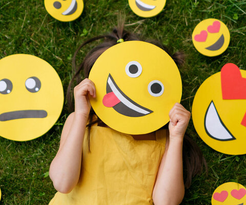 The,Child,Covers,His,Face,With,A,Emoticon,Showing,His