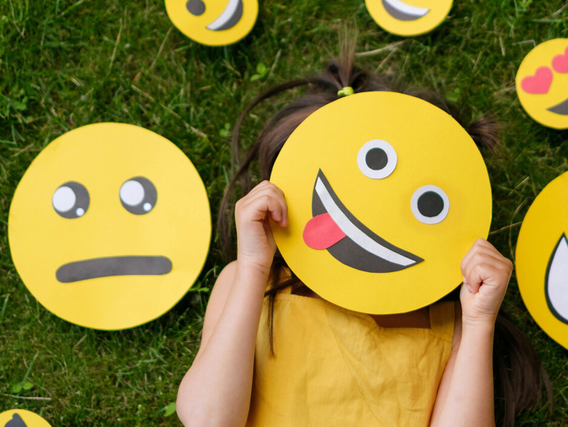 The,Child,Covers,His,Face,With,A,Emoticon,Showing,His